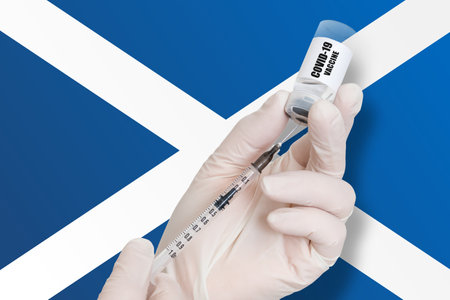 Vaccination in Scotland. Vaccine to protect against Covid-19 on background of national flag.の写真素材