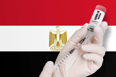 Vaccination in Egypt. Vaccine to protect against Covid-19 on background of national flag.の写真素材