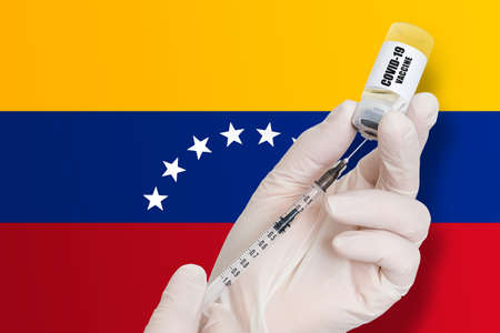 Vaccination in Venezuela. Vaccine to protect against Covid-19 on background of national flag.の写真素材