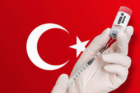 Vaccination in Turkey. Vaccine to protect against Covid-19 on background of national flag.の写真素材