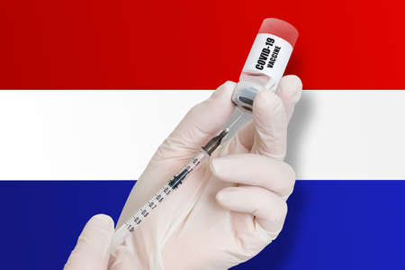 Vaccination in Netherlands. Vaccine to protect against Covid-19 on background of national flag.の写真素材