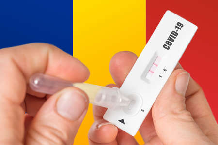 Positive rapid test on COVID-19 in Romania on background of national flagの写真素材