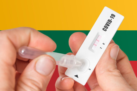 Positive rapid test on COVID-19 in Lithuania on background of national flagの写真素材