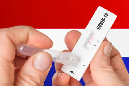 Positive rapid test on COVID-19 in Netherlands on background of national flagの写真素材