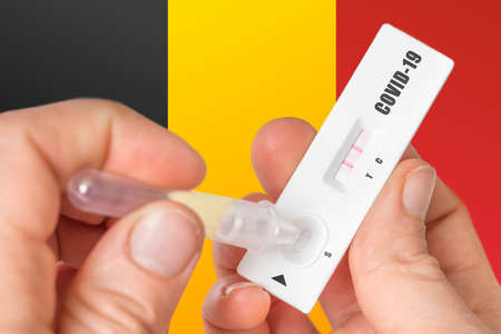 Positive rapid test on COVID-19 in Belgium on background of national flagの写真素材