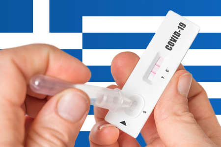 Positive rapid test on COVID-19 in Greece on background of national flagの写真素材