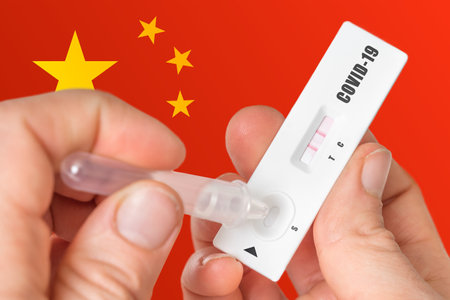 Positive rapid test on COVID-19 in China on background of national flagの写真素材