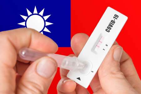 Positive rapid test on COVID-19 in Taiwan on background of national flagの写真素材