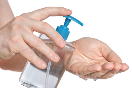 Man is applying antibacterial gel, sanitiser on his hands - hygiene conceptの写真素材