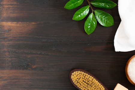 woman body, skincare, massage and bath products, sea salt in bowl, white towel, green leaves, cacus brush for dry massage on black wooden background. Beauty blogger cosmetics Copy space Horizontalの写真素材
