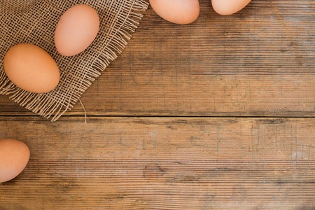 Eggs on natural rough cloth and wooden brown old textured background. Easter background with copy space for textの写真素材