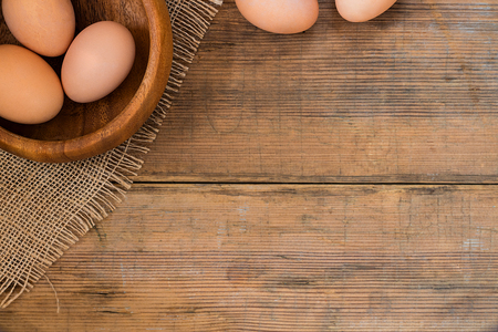 Eggs in bowl on wooden brown old textured background. Easter background with copy space for textの写真素材