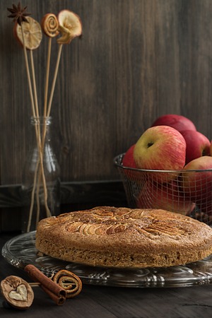Homemade apple pieon the grey wooden background with red apples and decorationsの写真素材