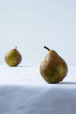 green pear with water drops on white background and defocused pearの写真素材