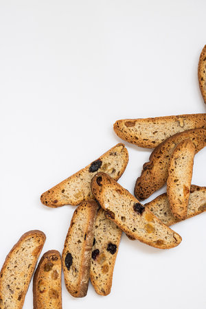 many long pieces of bright yellow and orange biscotti with white and black sultanas and nuts, dried...