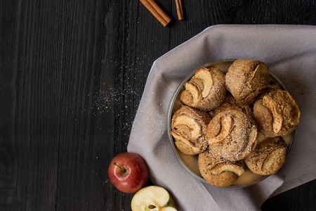 Healthy vegan oat muffins with apple and cinnamon in vintage pan and dish cloth on the dark wooden background. Top view. Copy spaceの写真素材