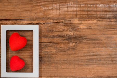 Pair of red hearts on vintage textured wooden table with copy space, top view with copy space. Saint Valentines day greeting card or background for picture or blogの写真素材