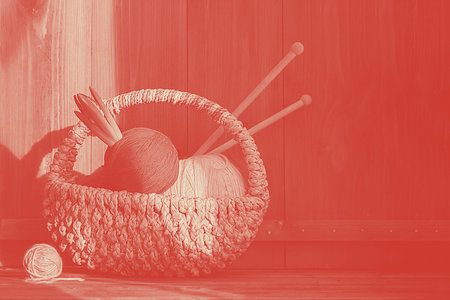 bright yarn with hyacinth in small basket with kniting sticks on old wooden background. Coral....