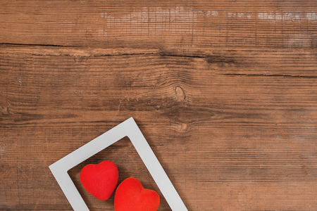 Pair of red hearts on vintage textured wooden table with copy space, top view with copy space. Saint Valentines day greeting card or background for picture or blogの写真素材