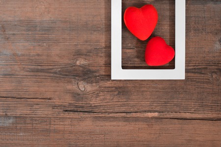Pair of red hearts on vintage textured wooden table with copy space, top view with copy space. Saint Valentines day greeting card or background for picture or blogの写真素材