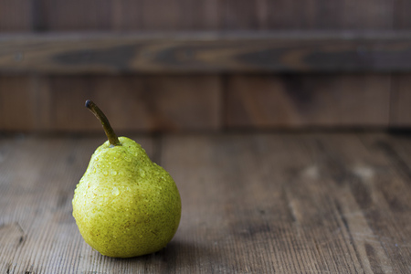 one fresh ripe organic yellow pear on rustic wooden brown table with defocused pears on background. Selective focus. Horizontal with copy space. For design about agricilture, frui, healthy foodの写真素材