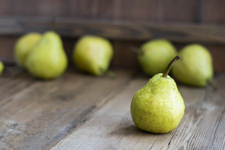 one fresh ripe organic yellow pear on rustic wooden brown table with defocused pears on background. Selective focus. Horizontal with copy space. For design about agricilture, fruit, healthy foodの写真素材