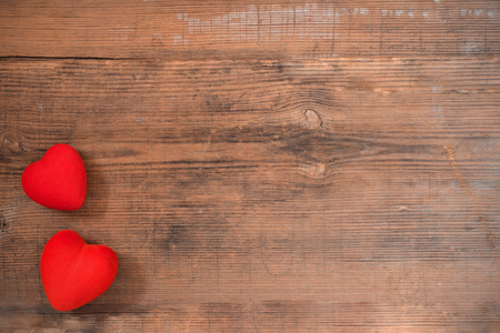 Pair of red hearts on vintage textured wooden table with copy space, top view. Saint Valentines day greeting card.の写真素材