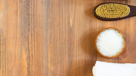woman skincare and body, massage and bath products, sea salt in wooden bowl, white towel, cacus brush for dry massage on brown textured wooden background. Beauty blogger cosmetics Copy space Bannerの写真素材