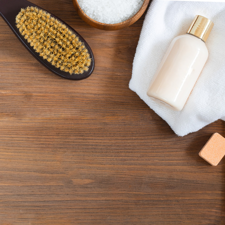 woman skincare and body, massage and bath products, sea salt in wooden bowl, white towel, cacus brush for dry massage on brown textured wooden background. Beauty blogger cosmetics Copy space Squareの写真素材