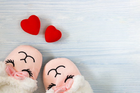 cute sleeping pink lama trendy slippers soft pastel colours with bright red hearts on wooden textured blue background Top view Soft slippers Love Valentine Conceptの写真素材