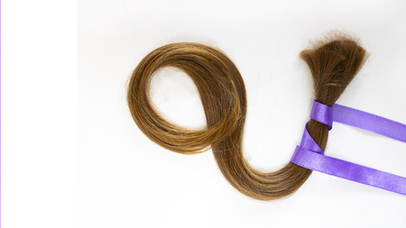 long blond hair donationwith lavender ribbon as symbol of fight against cancer on white background. Top view. Natural material for making wig for patients. Square with copy space, isolated.の写真素材