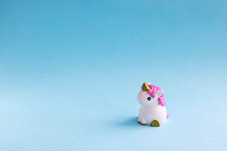 Cute white unicorn on the light blue pastel background. Baby shower, girl birthday concept. Horizontal, copy spaceの写真素材