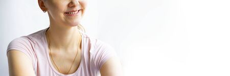 Red bubbles of virus herpes on lips of a woman in light pink t-shirt, lower part face is seen, lady is smiling. Medicine, treatment. Long horizontal banner with copy space. White backgroundの写真素材