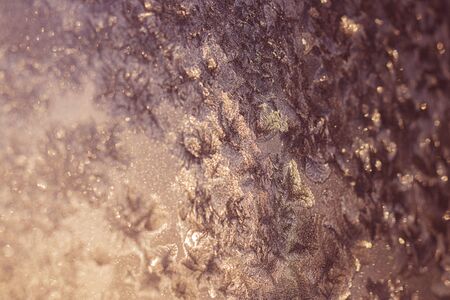 Ice patterns on winter glass of window, with the light seen through it. Light coral duotone. Selective focus. Creative background about winter, cold, christmas time. Horizontalの写真素材