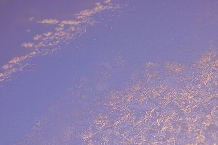 Ice patterns on winter glass of window, with the light seen through it. Light violet duotone. Selective focus. Creative background about winter, cold, christmas time. Horizontal banner.の写真素材