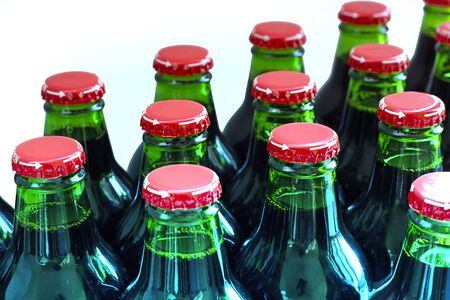 Green glass bottles without labels with dark liquid with metal easy twisting with arrow and word open on white background. Use without opener. Manufacture drinks, beverages. Horizontal with copy spaceの写真素材