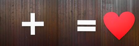 plus, equal and heart symbol on brown wooden wall. Long horizontal banner with copy space. Creative concept or wedding and St. Valentimes dayの写真素材