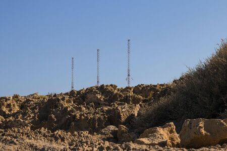Landscape near of Cavo Greco, neigborhood of Ayia Napa, Cyprus island, Mediterranean Sea. High red and white metal construstions over the spones, sunny day. Horizontalの写真素材