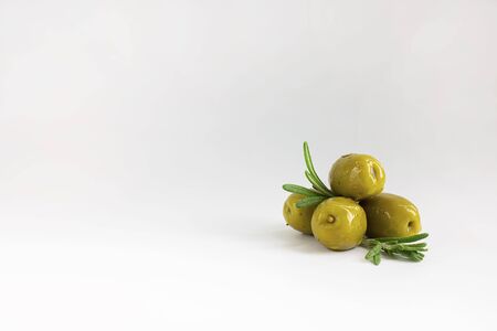 set of green marinated with herbs olives with fresh rosemary leaves on white background, horizontal with copy space. Isolate. Appetizer.の写真素材