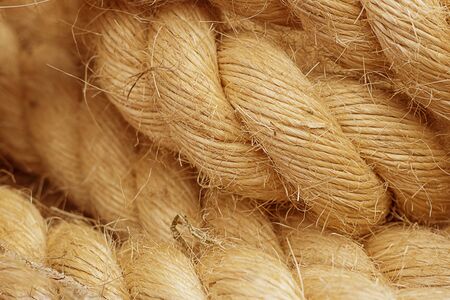 Rough Cord made from natural plant fiber. Rope detail, closeup. Wallpaper and background about fabtic manufacture, eco friendly material. Horizontal. Orange tone. Copy space.の写真素材