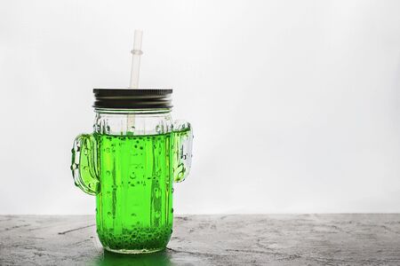 Smoothie trendy cactus shape jar with green basil seeds drink with straw on grey background with back light. Horizontal, copy space. Minimal concept about healthy beverage, super food. Falooda, sabjaの写真素材