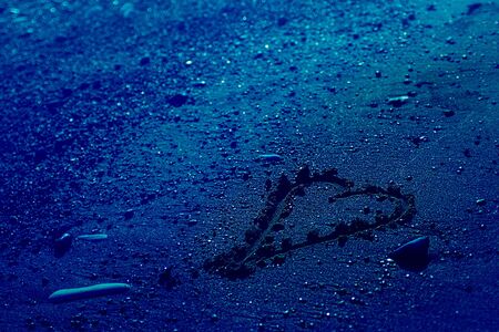 Heart on the sand beach. Conceptual design about relations, love and travelling, romantic holiday, honey moon. Classic, blue monochrome, trend 2020. St.Valentine's day on sea. Horizontal, copy space.の写真素材