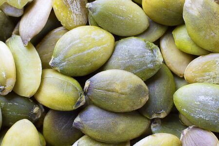 Macro background texture of dried green pumpkin seeds. Horizontal. Close up. Healthy food, veg, ingredientの写真素材