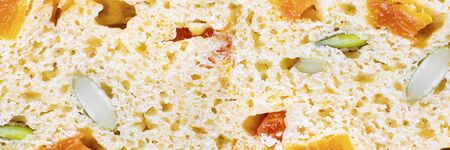 Whole wheat sweet bread texture with dried apricots and pumpkin seeds. Macro. Long horizontal banner for design.の写真素材