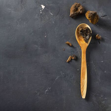 Wild Chaga Mushroom lives on birch bark, inonotus obliquus pieces in wooden spoon on dark background Ingredient for making tea, organic healthy hot drink, natural remedy, antioxidant. Copy space. Foodの写真素材