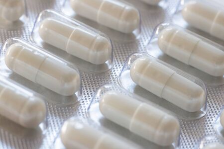 Pack of pills closeup. Diagonal row of oval long shape remedy. Background or texture about Medicine, Health, Vitamins which support human body, hepl to immune viruses and infections. Horizontalの写真素材