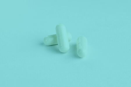 Tree pills macro. Oval long shape remedies. Blue tone. Background or texture about Medicine, Health, Vitamins which support human body, hepl to immune viruses, infectionsの写真素材