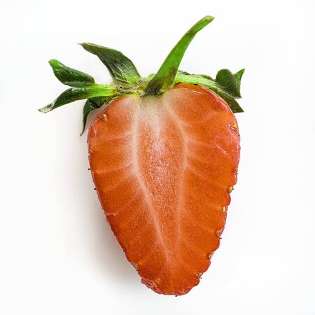 Isolated close up ripe red strawberry cut in half with green peduncle on a white background. square image about fresh organic berries, harvets, healthy food and vitamin. Macroの写真素材