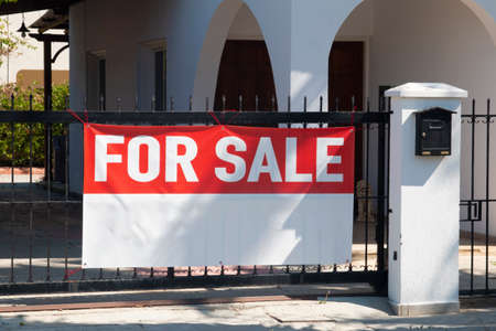 Long fabric mockup Banner with text FOR SALE and copy space on the iron fence. Sunny summer day. Horizontal shot about house, villa and real estate market. Property.の写真素材