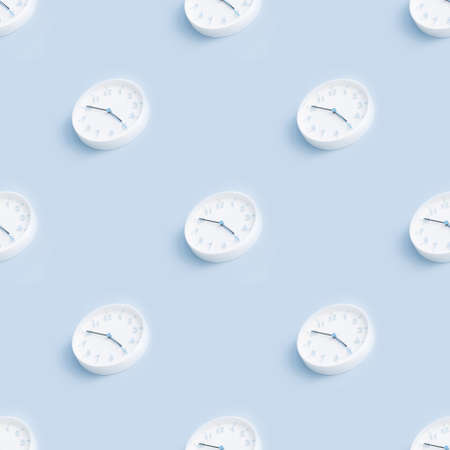 Seamless pattern with minimalistic round white wall clock on a light blue empty background. Time concept. Trendy picture.の写真素材